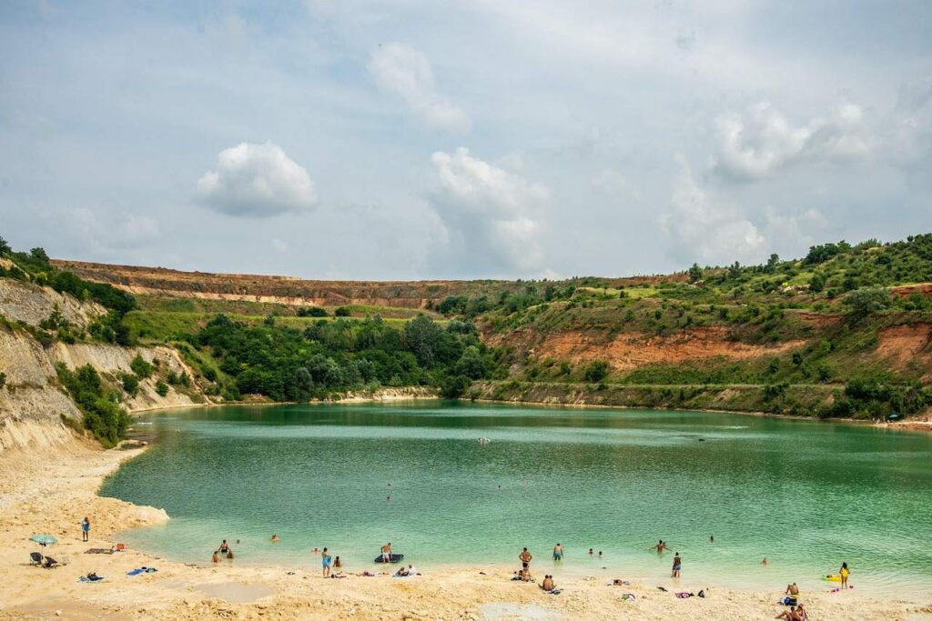 Kupalište na jezeru Beli kamen u Bešenovu na Fruškoj gori, ljudi se kupaju i odmaraju na plaži.
