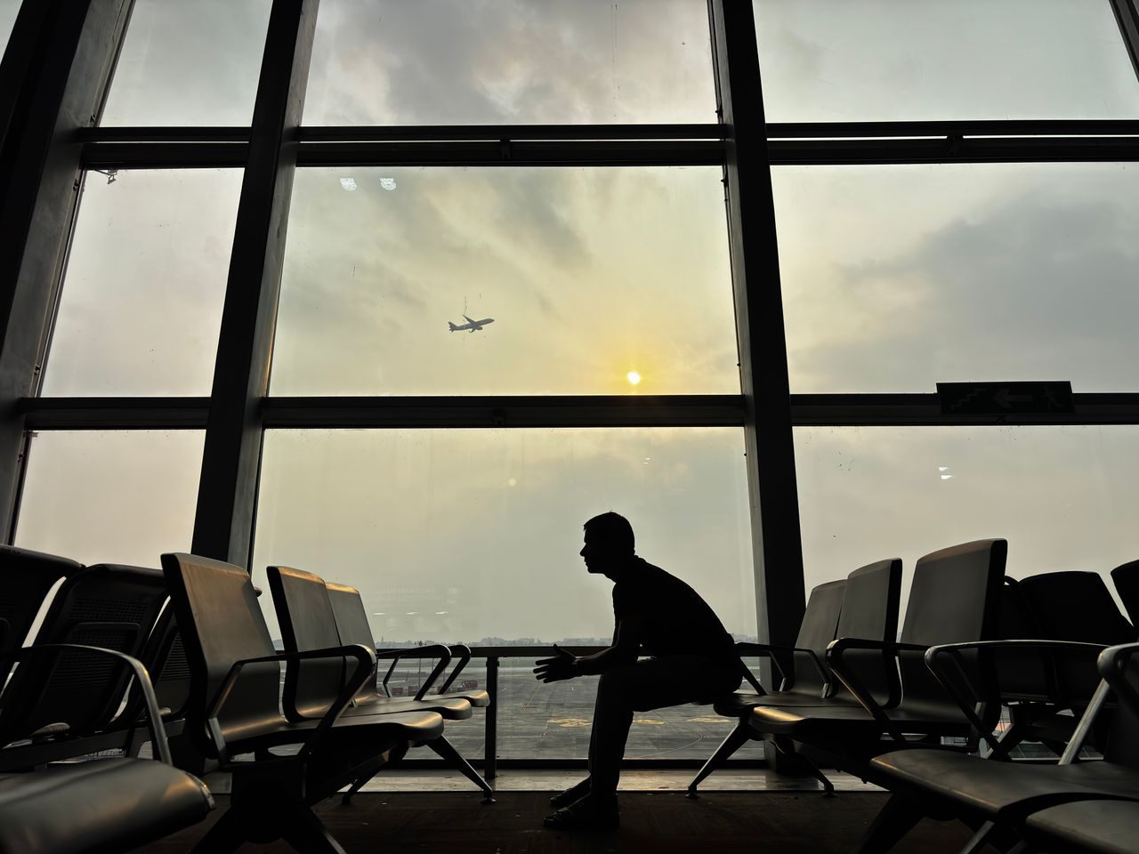 Čovek sedi na klupama na aerodromu